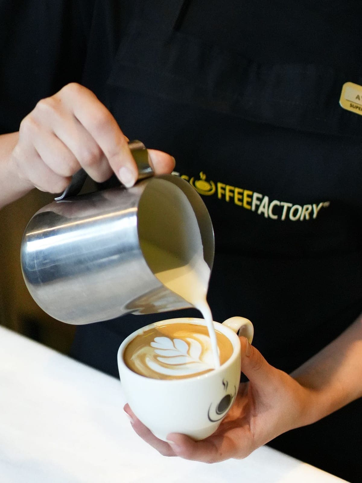 Milk being poured into a flat white